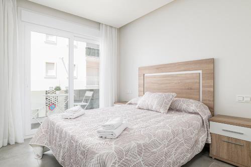 a bedroom with a bed with two towels on it at Apartamento Vidamar 1 in Conil de la Frontera