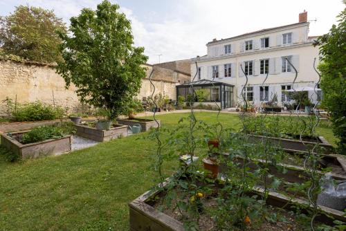 a garden with some plants in a yard at H de Surgères in Surgères