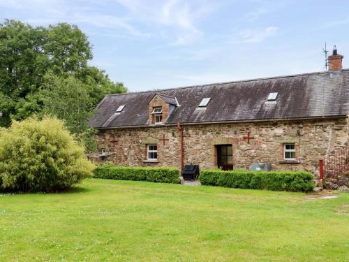 una antigua casa de piedra con un gran patio en Orchard Barn, en Wexford