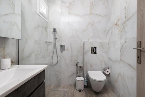 a white bathroom with a toilet and a shower at Carolina Apartment's in Zilotí