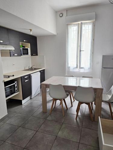 - une cuisine avec une table et deux chaises dans l'établissement Calme, à 15 minutes de la mer, à Pia