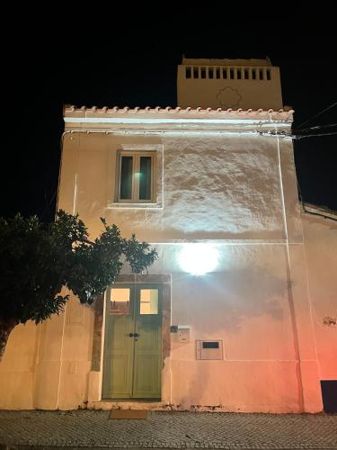 a building with a green door at night at Villa Nooma Alentejo in Vila Fernando