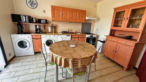 - une cuisine avec une table et un lave-linge/sèche-linge dans l'établissement La Villa du Claus avec Jacuzzi, Jardin et BBQ, à Saint-Mathieu-de-Tréviers