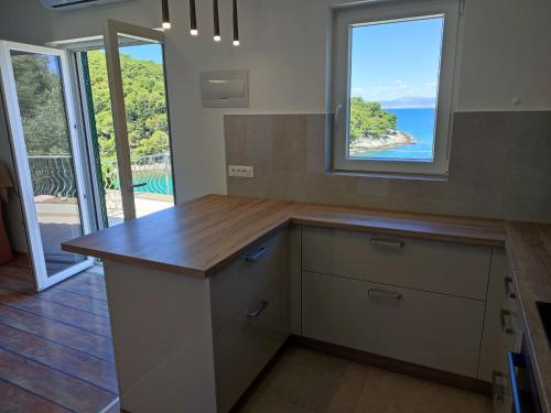 a kitchen with a counter with a view of the ocean at Apartment Jagoda in Postira