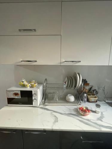 a kitchen with a white counter top with a microwave at Shabdan Guest House in Toktogul