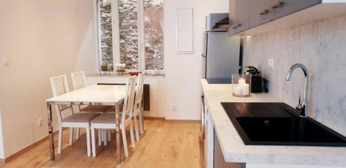 a kitchen with a sink and a table with chairs at maison ville st aff in Saint-Affrique