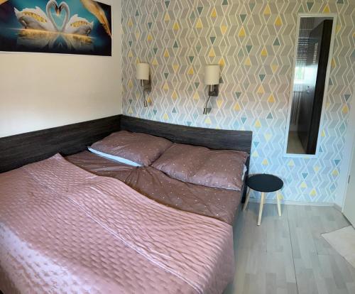 a bedroom with a large bed with a pink comforter at Golden-Beach Apartman in Siófok