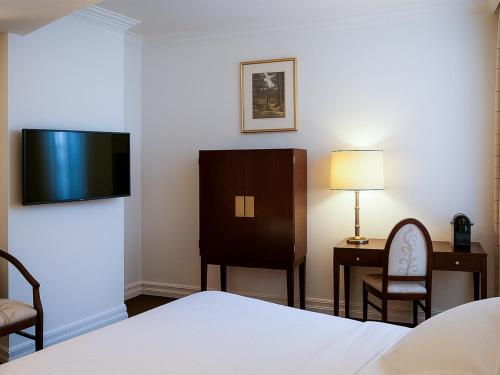 a hotel room with a bed and a flat screen tv at Hotel Du Parc - Mulhouse Centre in Mulhouse