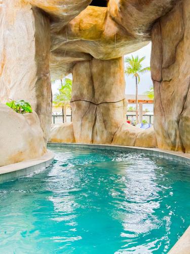 a pool in a resort with a rock wall at SALINAS PREMIUM - GAV Resorts in Salinópolis
