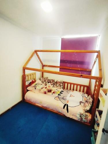 a childs bedroom with a wooden bunk bed at Departamento acogedor Arica in Arica