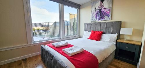 una camera da letto con un letto con una grande finestra di Bridge St 6 Bedroom House - Tranent a Tranent