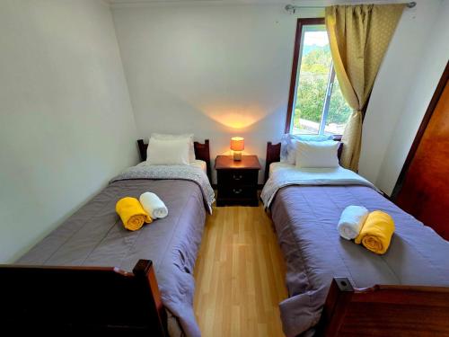 two twin beds in a room with a window at Encanto das Caldeiras in Furnas