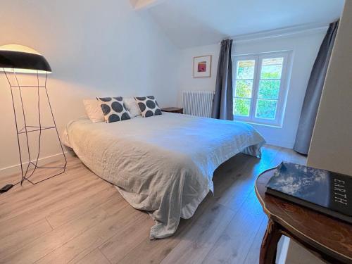 a bedroom with a bed and a desk and a window at Villa Oscar in Les Mesnuls