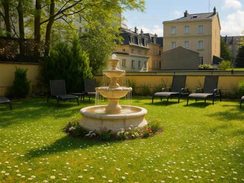 a fountain in the middle of a field of grass at Hotel Du Parc - Mulhouse Centre in Mulhouse