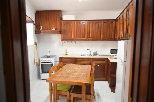 a kitchen with wooden cabinets and a table with chairs at Casa do Areal in Alenquer