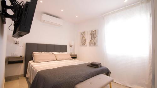 Un dormitorio con una cama y una silla y una ventana. en Apartamento lliteras ref 9003, en Cala Millor