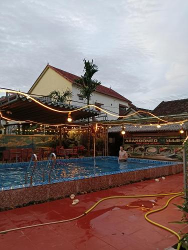 a person sitting in a swimming pool next to a building at Phong Nha Magic Fingers Homestay and Spa in Phong Nha