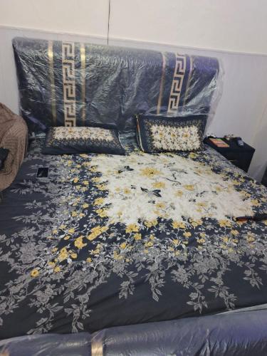 a bed with a blue comforter and pillows at HEAVEN House in Dargai