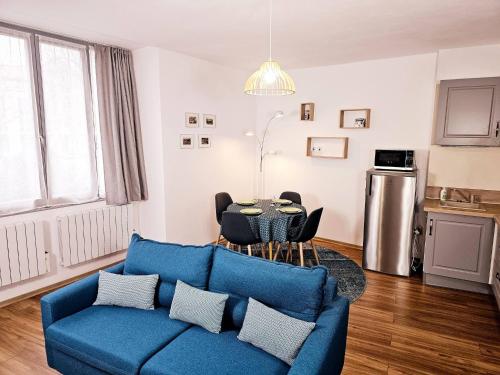un salon avec un canapé bleu et une table dans l'établissement t2 hardy, à Millau