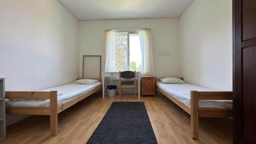 a room with two beds and a window at Ollinpolun matkakoti in Sulkava
