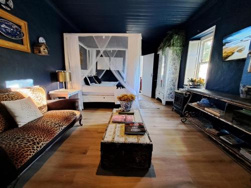 a living room with a couch and a bed at Olive grove cottage in Koringberg