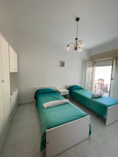 a bedroom with two beds and a window at Jimmy 's House in Brolo