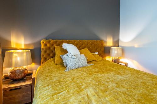 a bedroom with a large yellow bed with two lamps at Jasmin Holiday House Kassaris 