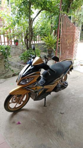 a motorcycle parked on a sidewalk next to a fence at Phong Nha Magic Fingers Homestay and Spa in Phong Nha