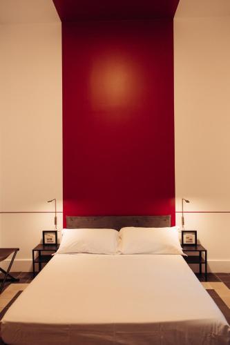 a bedroom with a large bed with a red wall at Altoledo Rooms and Suite in Naples