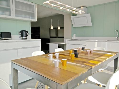 uma cozinha com uma mesa de madeira e armários brancos em Ferran Pedralbes Penthouse em Barcelona