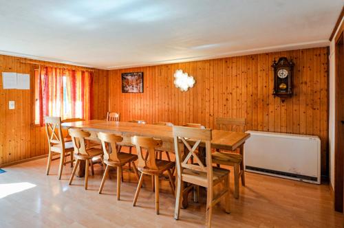 a dining room with a large wooden table and chairs at Chalet Les Bardeaux in Randogne