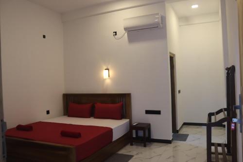 a bedroom with a bed with red pillows at Elite Bay Arugambay in Arugam Bay
