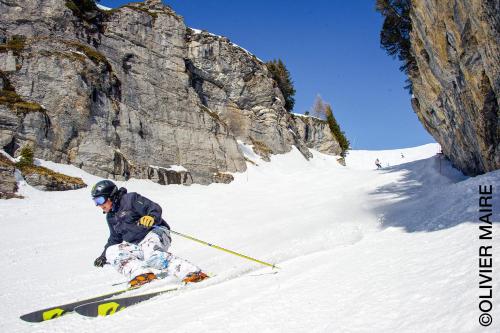 a man is skiing down a snow covered mountain at Chalet Les Bardeaux in Randogne