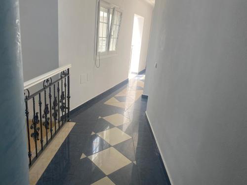 a hallway with a tile floor and a stair case at Hostal Restaurante La Niña in Palos de la Frontera