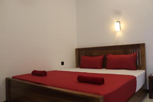 a bedroom with a large bed with red pillows at Elite Bay Arugambay in Arugam Bay