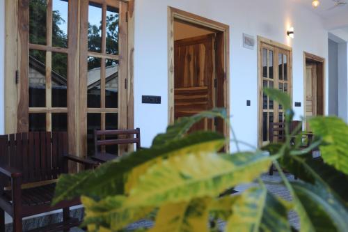 a room with doors and chairs and a plant at Elite Bay Arugambay in Arugam Bay