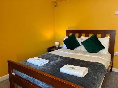 a bedroom with a bed with two towels on it at OceanNest-3 Bedroom Apartment free parking, EV 22kW in Portsmouth