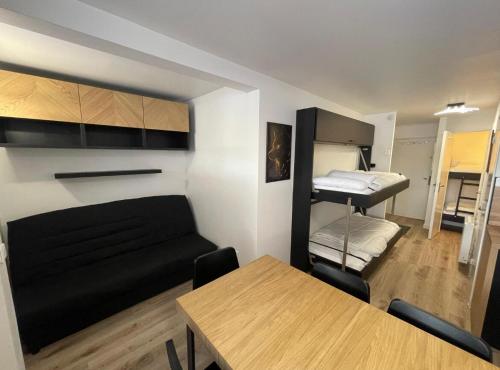 Cette chambre comprend un canapé, une table et un lit. dans l'établissement Appartement Montagne Randonnées centre la Foux d'Allos - Eté & Hiver, à Allos
