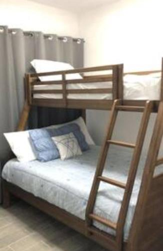 a bunk bed with a white mattress and a ladder at La Casita in Puerto Peñasco