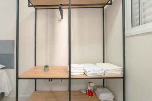 a room with a shelf with towels on it at Apartamento Confortável - MEL402 in Maringá