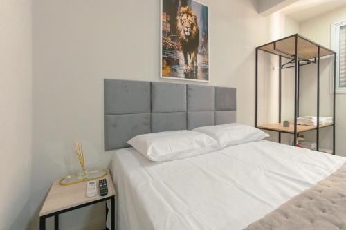 a bedroom with a large white bed with a picture on the wall at Apartamento Confortável - MEL402 in Maringá