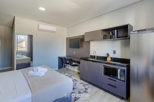 a room with a bed and a kitchen in a room at TCO - Apartamentos no Centro Histórico Porto Alegre/RS in Porto Alegre
