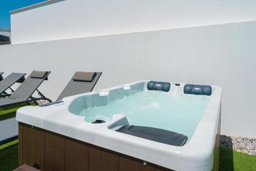 ein Whirlpool in einem Gebäude mit Stühlen in der Unterkunft Villa Lola in Mariquiteira
