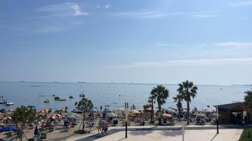 a beach with many umbrellas and boats in the water at Beautiful Sea View Apartment in Durrës