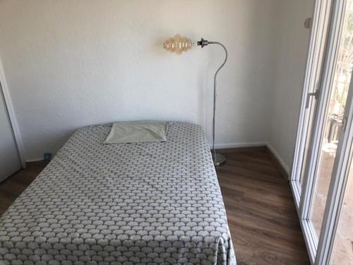 - une chambre avec un lit et une lampe dans l'établissement 2 Pièces 4 personnes à 100 m de la plage, à Saint Cyprien Plage