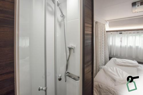a small room with a bed and a door with a green tag at HOTIDAY Lodge Castiglione in Castiglione della Pescaia