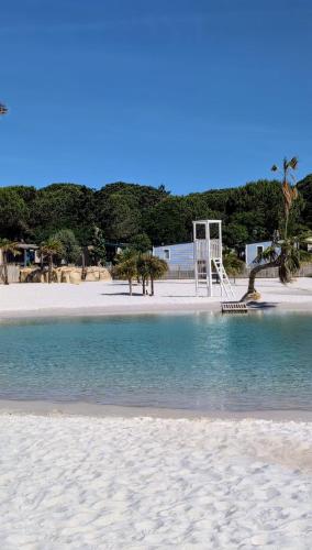 une plage avec une aire de jeux et une balançoire dans l'établissement Mobile-home, terrasse, pour 6 à 8p, Camping domaine de la Yole 5 étoiles, à Vendres