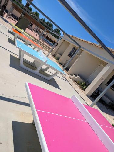 une rampe rose et une table de pique-nique devant une maison dans l'établissement Mobile-home, terrasse, pour 6 à 8p, Camping domaine de la Yole 5 étoiles, à Vendres