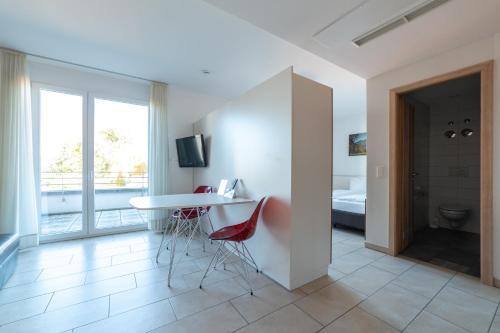 a room with a table and chairs and a bathroom at first Apart in Erlangen