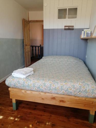 a bed in a bedroom with a wooden floor at File dans ta chambre ! in Le Monastier sur Gazeille